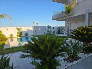 a view of a house with palm trees and a swimming pool at Villa Sunrise in Hammamet