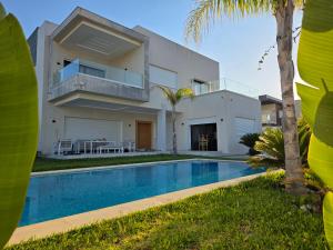 a house with a swimming pool in front of it at Villa Sunrise in Hammamet