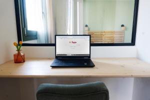 a laptop computer sitting on top of a wooden desk at Cotto Apartment in Agios Nikolaos +11 photos