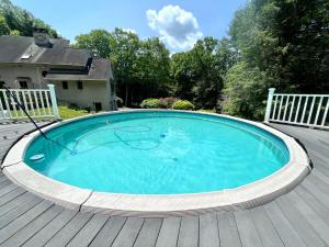 a large swimming pool on a wooden deck at SunnyPeace Modern Home Stay in Harwinton