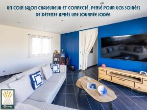a living room with a couch and a tv at Les Alizés in Plouhinec