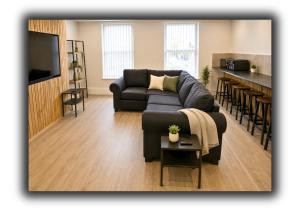 a living room with a couch and a kitchen at Williamson Suites - Apartment 1 in Liverpool