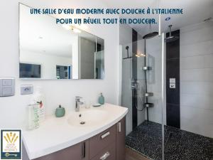 a bathroom with a sink and a shower with a mirror at Les Alizés in Plouhinec +23 photos
