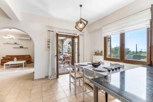 a kitchen and living room with a table and a couch at Villa Meli in Methoni