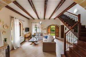 a living room with a couch and a staircase at Villa Areti by Villa Plus in Spiliá