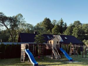 a play yard with a playground with slides at Domki Zielony Raj Rabka- Zdrój Jacuzii na wyłączność Sauna in Rabka-Zdrój