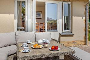 a table with plates of fruit on it on a patio at 5 Bed in Croyde oc-bonac in Croyde
