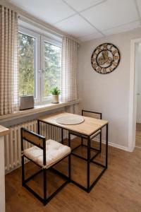 a dining room with a table and two chairs and a clock at Apartment Landglück Overath in Overath