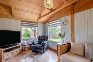 a living room with a television and a chair at 2 Bed in Keddington oc-t32411 in Louth