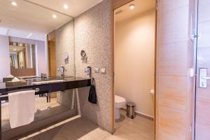 a bathroom with a sink and a toilet at Wyndham Concepcion Pettra in Concepción