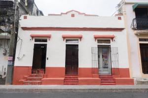 a white and red building with doors and stairs at Colonial studio with 2 Beds - Patio Español in Santo Domingo