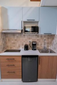 a kitchen with a sink and a microwave at Colonial studio with 2 Beds - Patio Español in Santo Domingo +4 photos