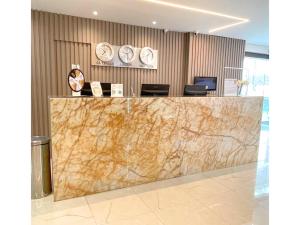 a lobby with a marble counter with clocks on the wall at Hotel Arujá in Arujá +36 photos