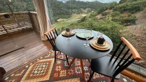 a table with wine glasses and chairs on a balcony at Sunrise in Domingos Martins