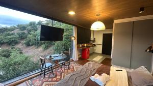 a living room with a large window with a tv at Sunrise in Domingos Martins