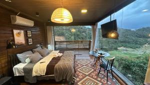 a bedroom with a bed and a large window at Sunrise in Domingos Martins