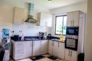 a kitchen with wooden cabinets and a sink and a window at Lihanda Villa in Kilifi