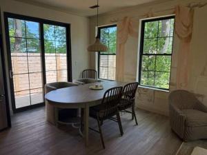 a living room with a table and chairs and windows at Maison Foxglove - Petite Acres Chateau in New Buffalo