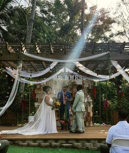 a bride and groom standing in front of a tent at Jardin al Bosque-Glamping in San Juan