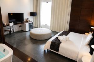 a hotel room with a large bed and a tub at BTH Hotel – Boutique Concept in Lima
