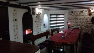 a dining room with a table and a fireplace at Guesthouse Orlovo in Orlovo