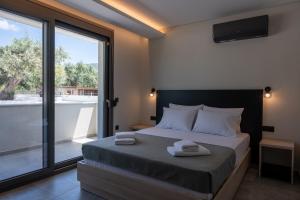 a bedroom with a bed with two towels on it at Psarras Deluxe Suites in Limenas