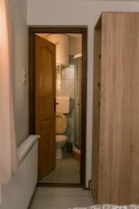 eine offene Tür zu einem Badezimmer mit Toilette in der Unterkunft Vila RID in Perućac + 31 Fotos