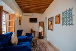 a living room with blue furniture and a wooden ceiling at Riad el Fenna 1974 in Chefchaouen