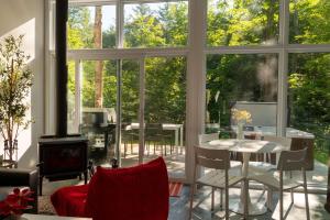 a living room with a large window and a table and chairs at The Lofti in Sainte Béatrix