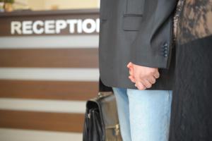 a woman with her hand in her pocket holding a suitcase at Hotel Alexander in Sofia