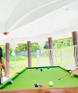 a woman standing next to a pool table at Maota Hotel Apia in Apia