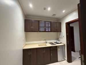 a kitchen with wooden cabinets and a sink at Akarem New - Al Safa - اكــارم - الصفا in Jeddah