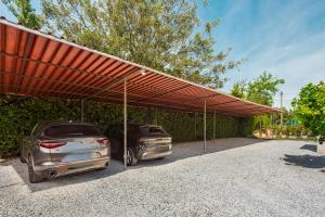 two cars parked under a large red canopy at Hotel La Perla in Marina di Massa