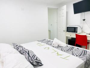 two beds in a room with a desk and a microwave at Maota Hotel Apia in Apia +2 photos
