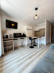 a living room with a kitchen with a table and chairs at Chaleureux appartement moderne in Briançon