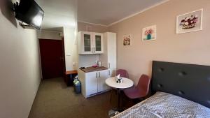 a small room with a bed and a table and a small kitchen at NASZE BIAŁE pokój 2 osobowy in Okuninka