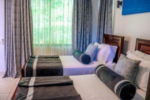 a hotel room with two beds and a window at Lihanda Villa in Kilifi +53 photos