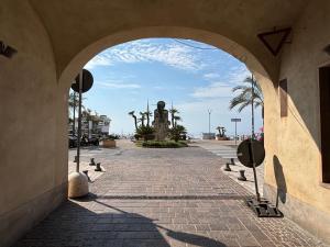 an archway in a building with a clock tower in the distance at Cà di Righe in Pietra Ligure