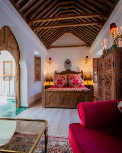 a bedroom with a large bed and a couch at Riad el Fenna 1974 in Chefchaouen