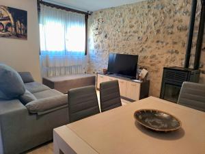 a living room with a couch and a television at Casa Rural Tarayuela in Cantavieja