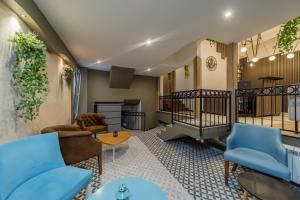 a living room with blue furniture and a staircase at City Code InJoy RENEW in Belgrade