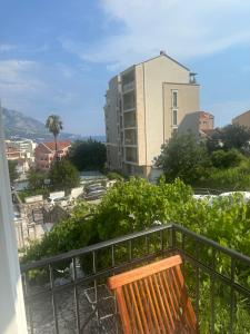 a wooden bench sitting on a balcony with a building at UROS apartments in Boreti