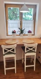 a kitchen with a wooden table and two stools at Calma Apartments Gattendorf in Gattendorf +14 photos