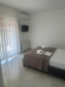 a bedroom with a large bed and a television at UROS apartments in Boreti