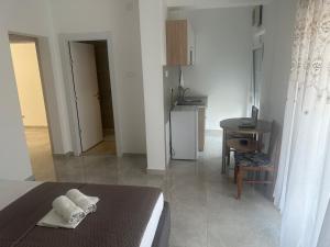a room with a bed and a table and a kitchen at UROS apartments in Boreti