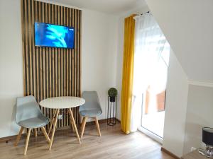a dining room with a table and two chairs at Noclegi Pod Lasem in Polańczyk