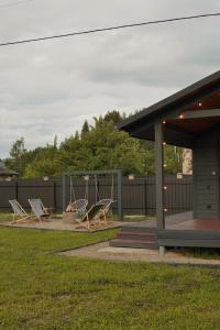 a group of chairs and a swing in a yard at Runa House in Verkhovyna