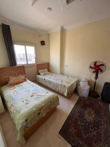 a bedroom with two beds and a lamp and a rug at Sami inn in Al Ghuşnah