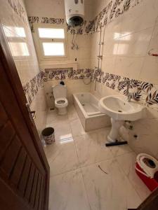 a bathroom with a sink and a toilet and a tub at Sami inn in Al Ghuşnah