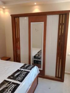 a bedroom with a bed and a large mirror at Sami inn in Al Ghuşnah